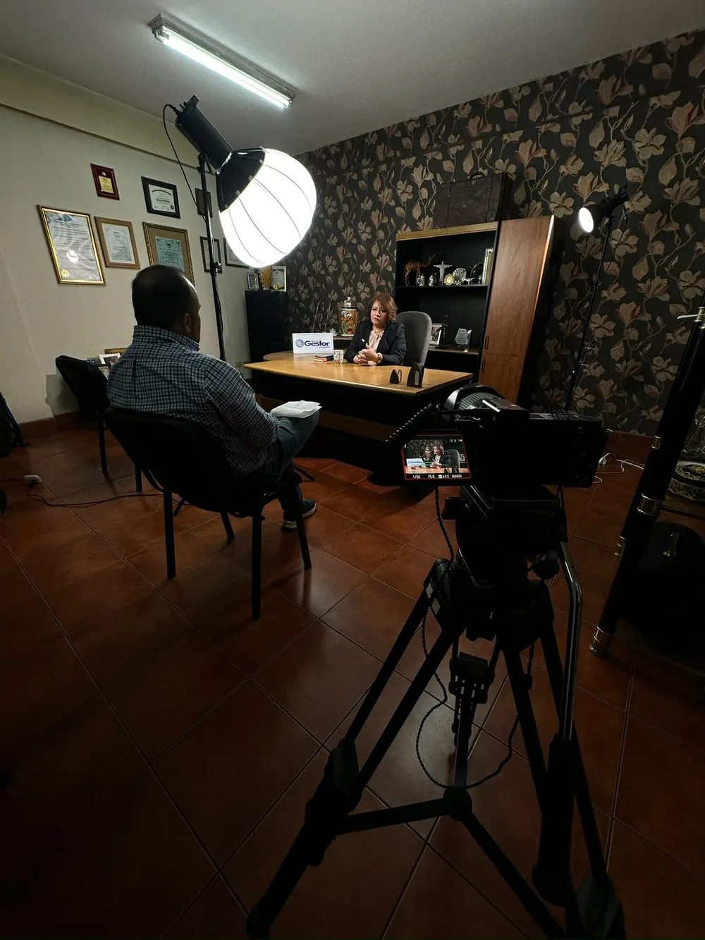 Entrevista grabada en un despacho, con luz de globo y monitor de campo